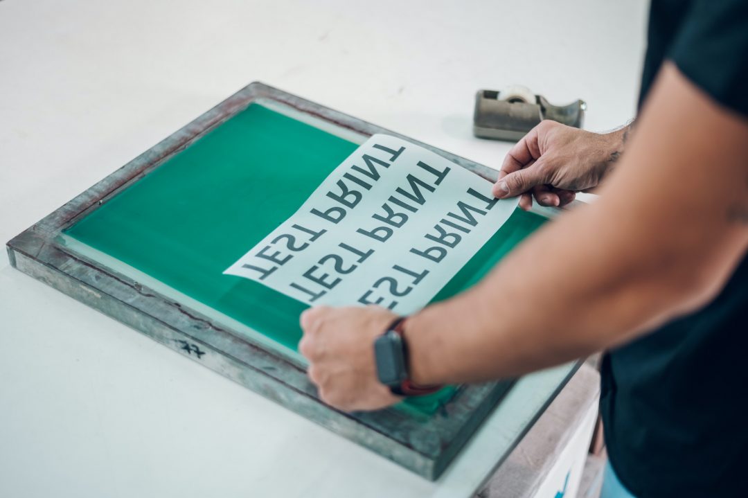 male-worker-preparing-screen-printing-film-in-workshop.jpg