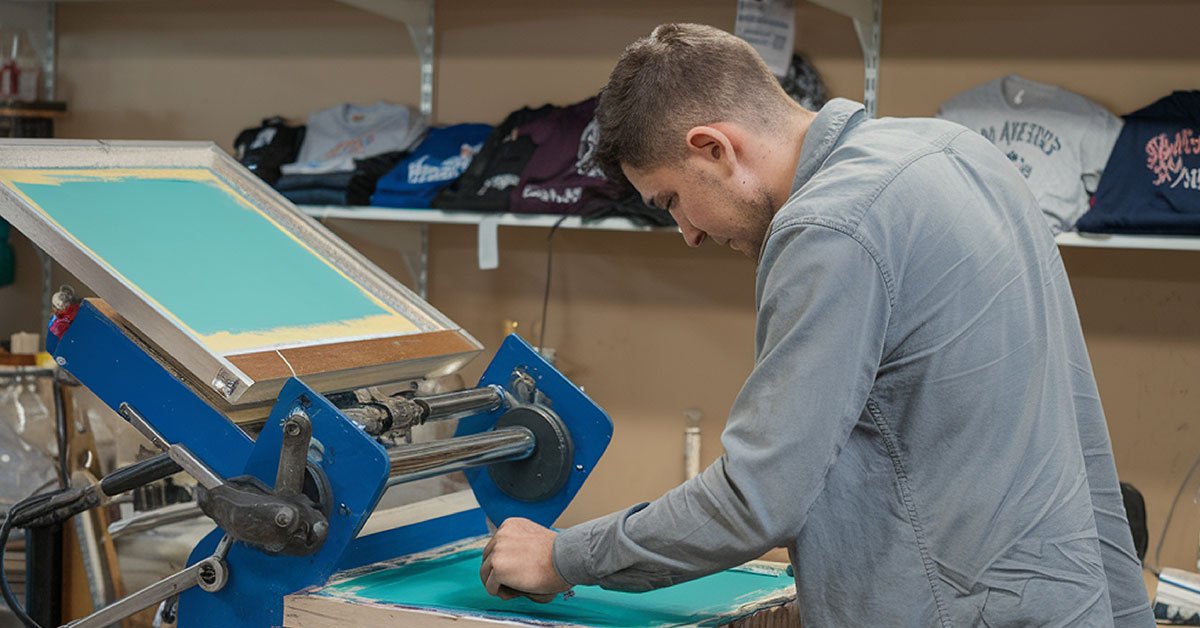 Professional operating screen printing machine demonstrating t-shirt printing methods pros and cons in production facility